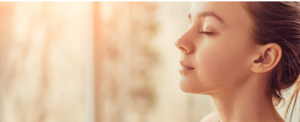 A woman taking a deep breath of clean, fresh air. Stock photo from canva for our Indoor Air Quality blog.