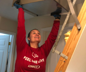 Rachelle lifting the new furnace up into the attic