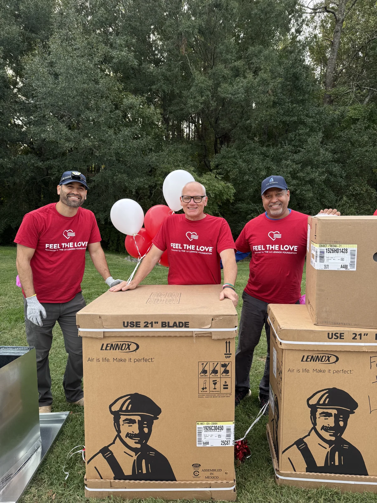 Three Air Experts crew members standing with the new Lennox equipment and balloons before an install