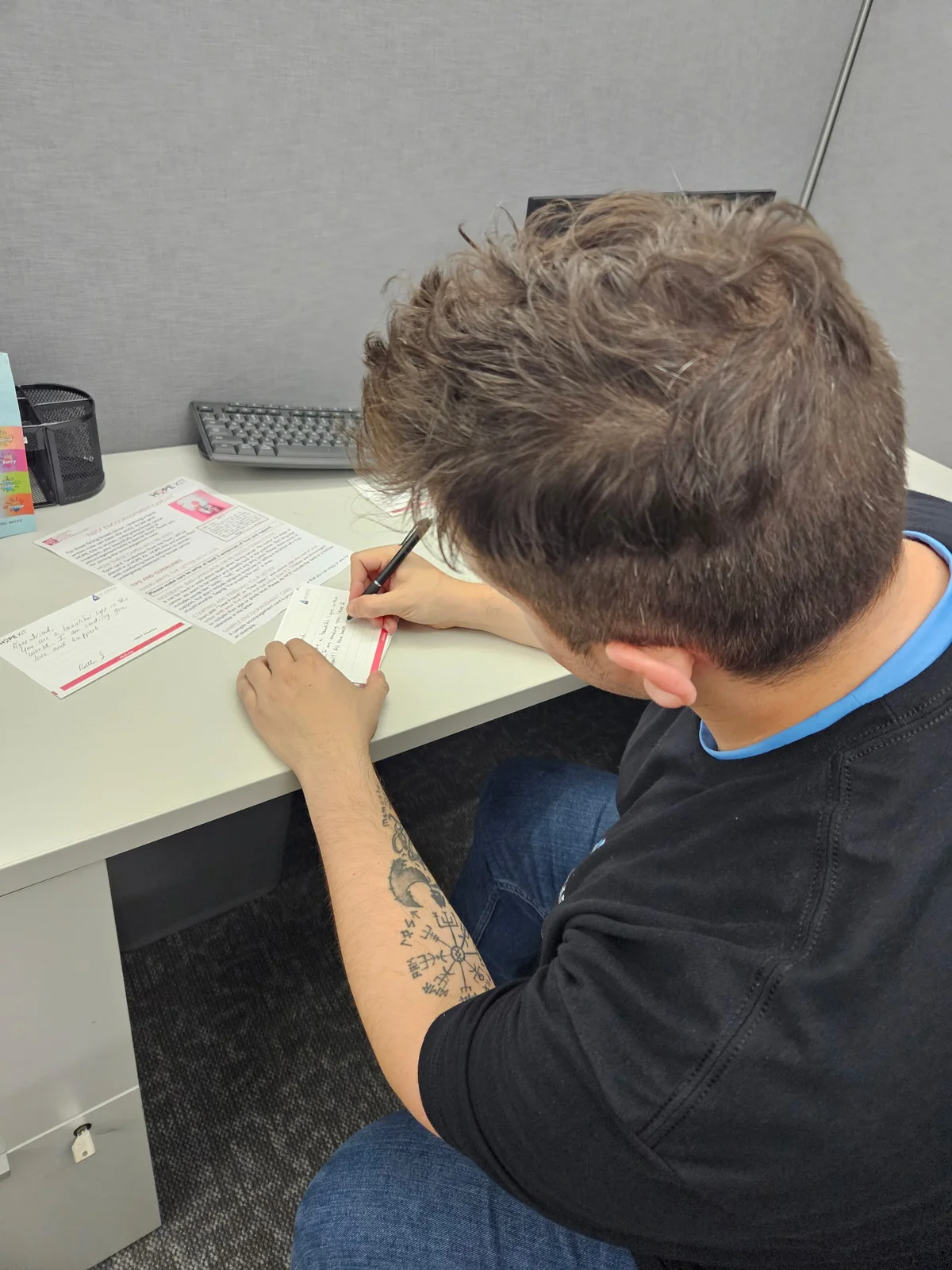 Air Experts employee handwriting an encouragement card for a Hope Kit