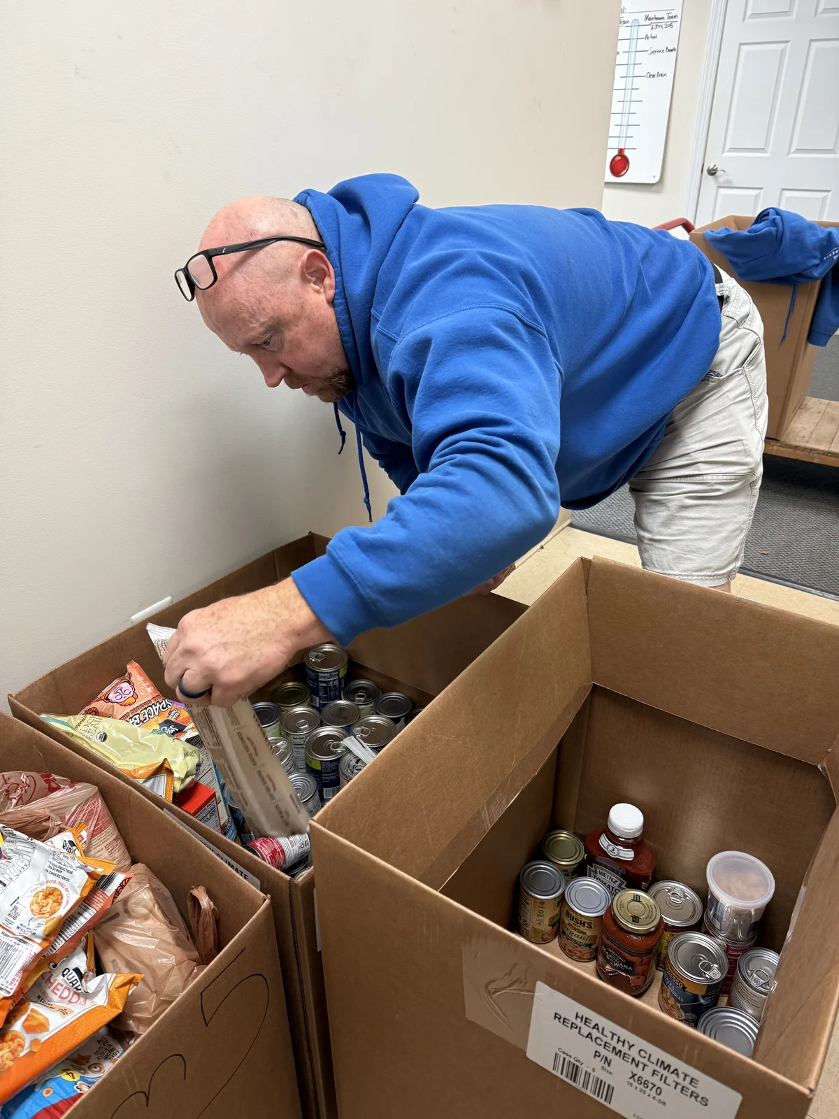 Air Experts employee sorting donated food into boxes at the office