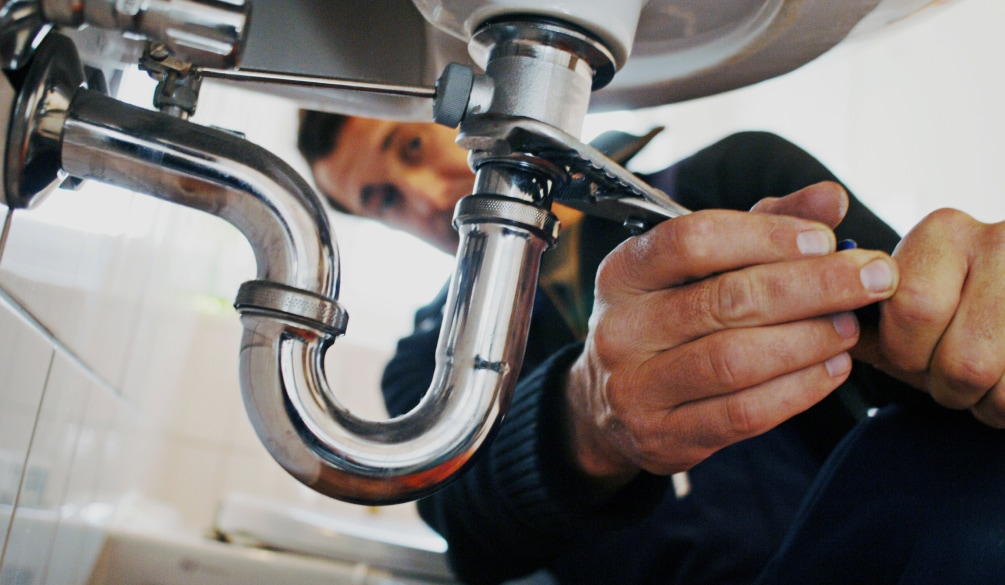 Plumber working on a pipe.