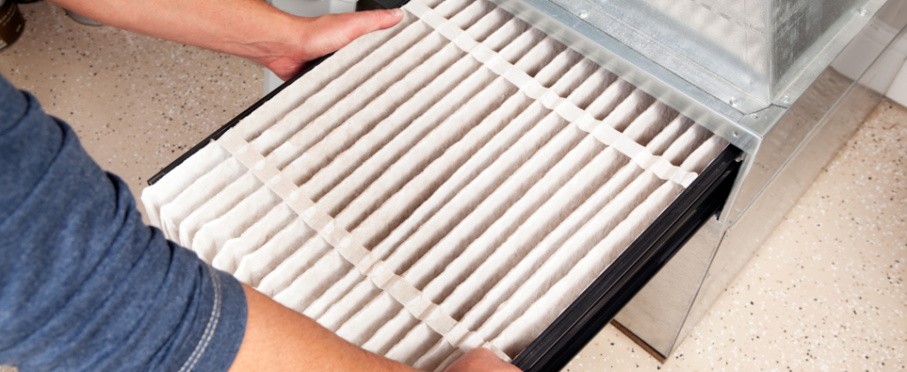 A stock photo of someone changing a filter for our AC maintenance blog.